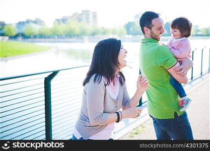 Mid adult couple with toddler daughter at riverside