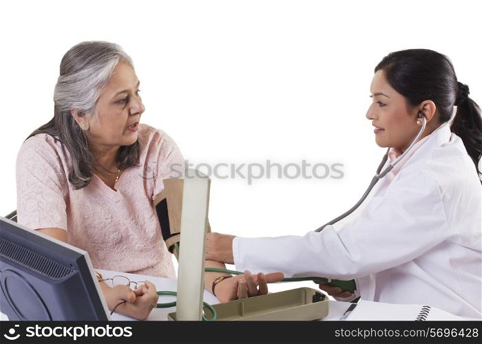 Mid adult doctor checking patient&rsquo;s blood pressure