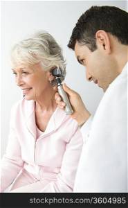 Mid adult doctor examining senior patient