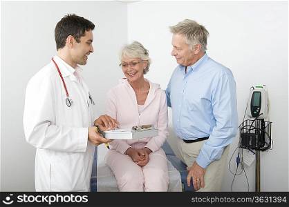 Mid adult doctor explains test results to senior couple