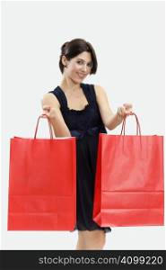 Mid adult Italian woman holding red shopping bags on white background
