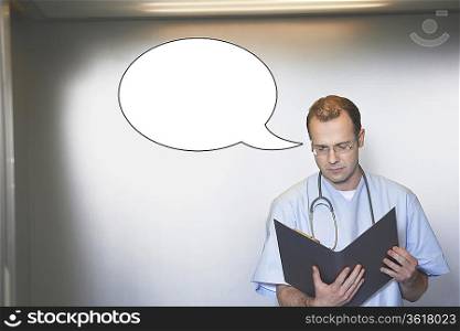 Mid adult male surgeon reading medical report with thought bubble