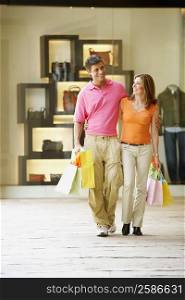 Mid adult man and a mature woman carrying shopping bags