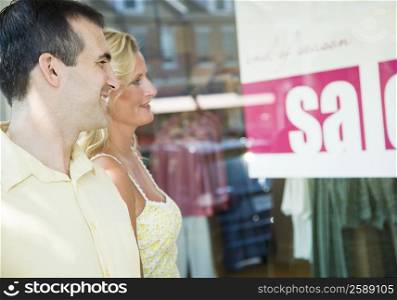 Mid adult man and a mature woman standing in front of a window display
