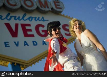 Mid adult man and a mid adult woman dressed in costumes, Las Vegas, Nevada, USA
