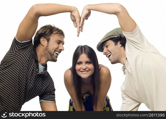 Mid adult man and a young man making a heart shape in front of a young woman