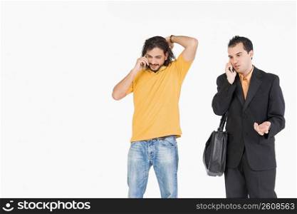 Mid adult man and a young man talking on mobile phones