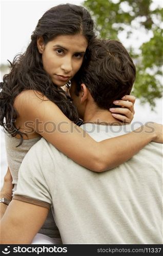 Mid adult man and a young woman embracing each other