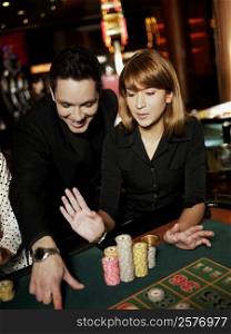 Mid adult man and a young woman gambling in a casino