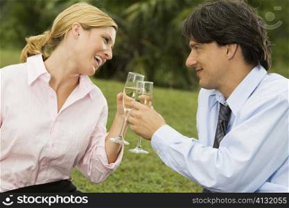 Mid adult man and a young woman holding champagne flutes