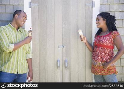 Mid adult man and a young woman holding ice creams