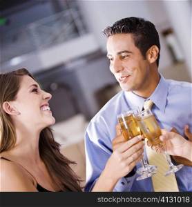 Mid adult man and a young woman raising a toast
