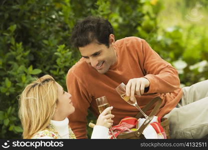 Mid adult man and a young woman toasting with champagne