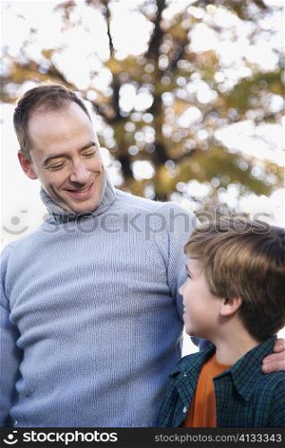 Mid adult man and his son looking at each other and smiling