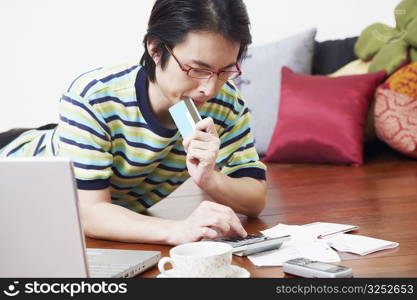 Mid adult man calculating bills using a calculator