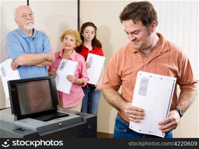 Mid-adult man checking out the new optical scan voting machine at the polls.