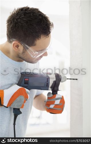 Mid-adult man drilling in wall