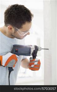 Mid-adult man drilling in wall