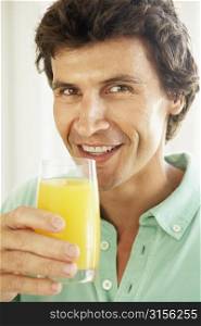 Mid Adult Man Drinking A Glass Of Orange Juice