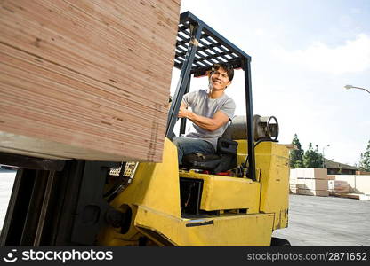 Mid-adult man driving forklift