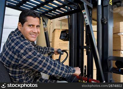 Mid-adult man driving forklift truck