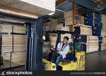 Mid-adult man driving forklift truck
