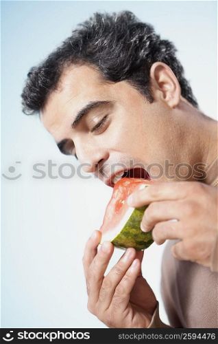 Mid adult man eating a watermelon slice