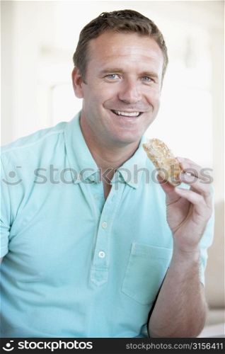 Mid Adult Man Eating Brown Bread Roll