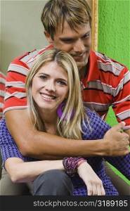Mid adult man embracing a young woman and smiling