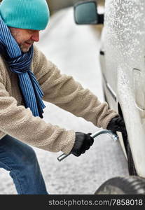 Mid adult man exchanging tire on the road