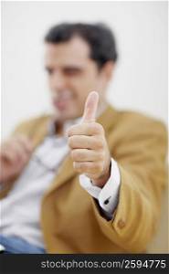 Mid adult man giving a thumbs up sign