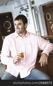 Mid adult man holding a glass of beer and smiling