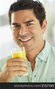 Mid Adult Man Holding A Glass Of Fresh Orange Juice, Smiling At The Camera