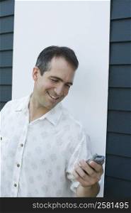 Mid adult man holding a mobile phone and smiling