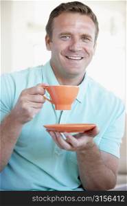 Mid Adult Man Holding Orange Mug And Smiling At The Camera