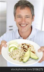 Mid Adult Man Holding Plate Of Healthy Food