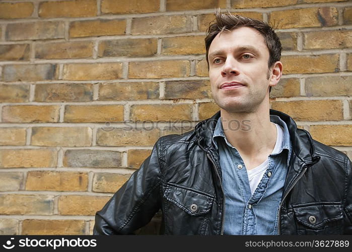 Mid-adult man in a leather jacket looking away