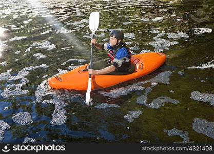 Mid adult man kayaking on peaceful river
