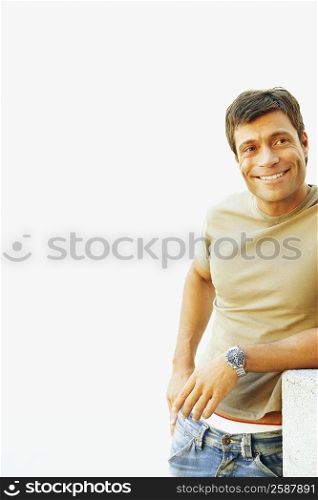 Mid adult man leaning against a structure