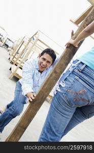 Mid adult man leaning against a wooden column in front of a young woman