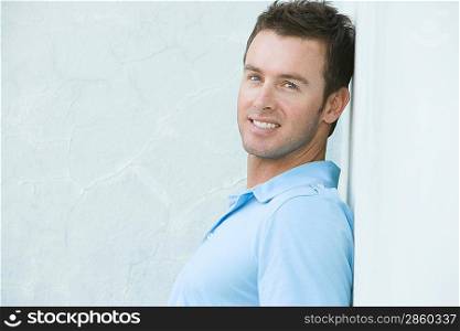 Mid-adult man leaning against the wall