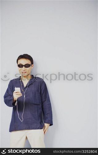 Mid adult man listening to an MP3 player and smiling