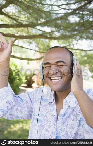 Mid adult man listening to music with headphones