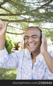 Mid adult man listening to music with headphones