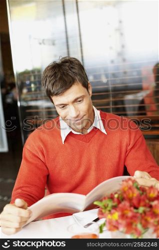 Mid adult man looking at a menu in a restaurant