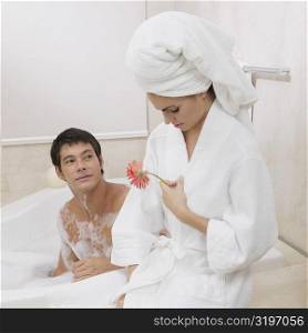 Mid adult man looking at a young woman sitting near him in the bathtub