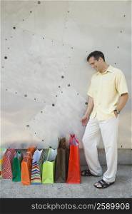 Mid adult man looking at bags and smiling