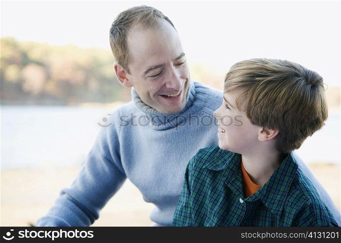 Mid adult man looking at his son and smiling