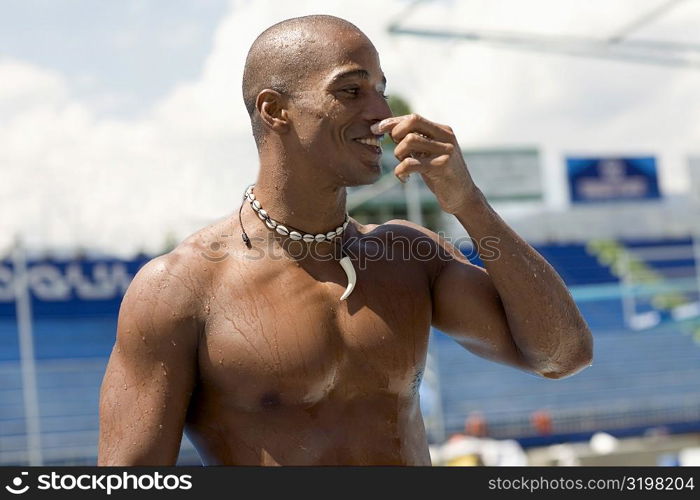 Mid adult man looking sideways at the poolside