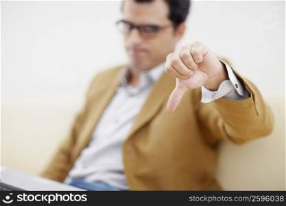 Mid adult man making a thumbs down sign
